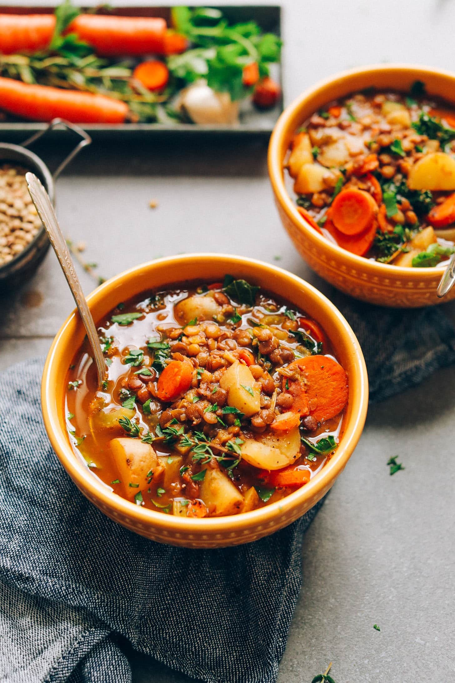 Bowls of homemade 1-Pot Lentil Soup with potatoes and carrots garnished with thyme