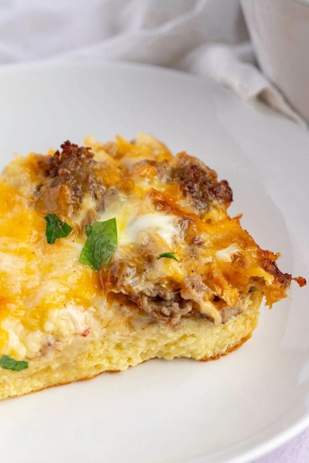 Slice of Paula Deen breakfast casserole on a white plate. 