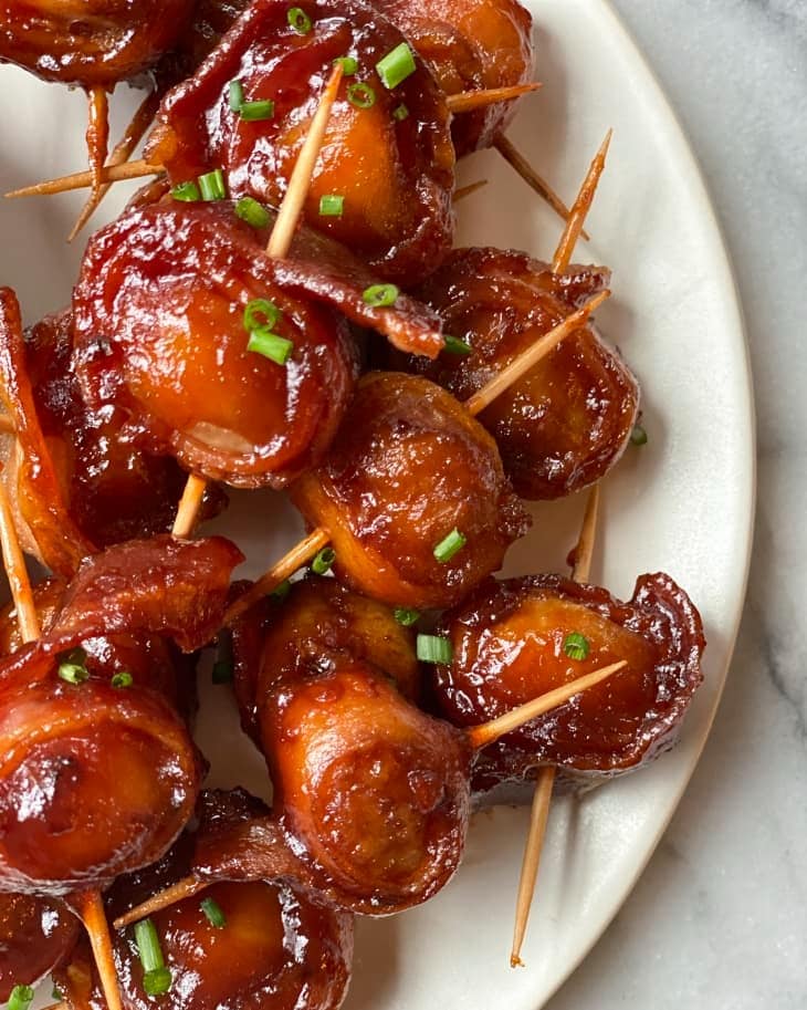 Glazing bacon wrapped water chestnuts served on a white plate. 