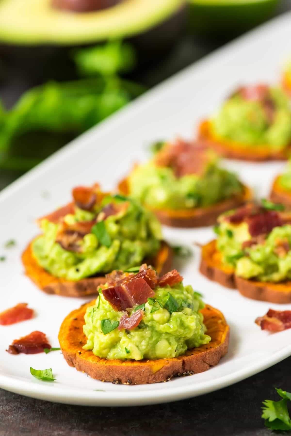 Sweet potato bite stopped with avocado salsa and bacon bites. 