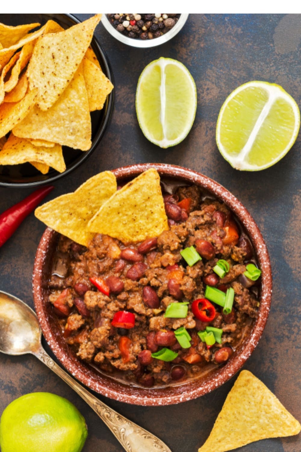 Bowl of Chili with nachos and slice lime on the side