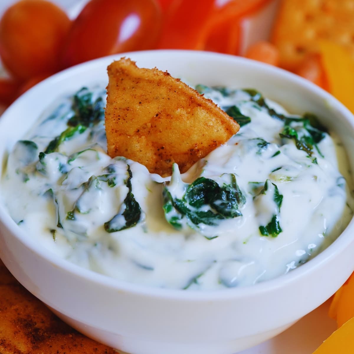 Creamy spinach dip on a white bowl.