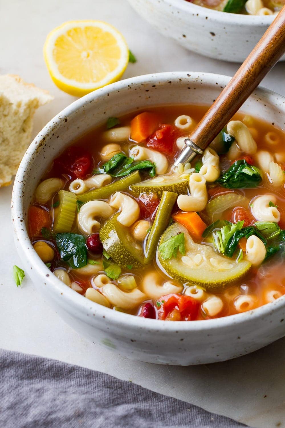 Bowl of homemade Minestrone Soup with carrots, celery stalks, red kidney beans, dice tomatoes. zucchini, green beans and peas