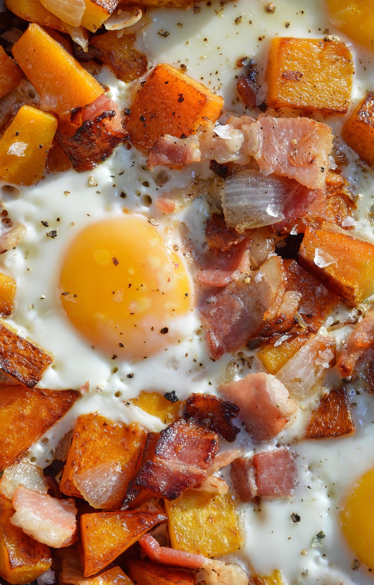 Breakfast has made with eggs, butternut squash, bacon, and onions. 