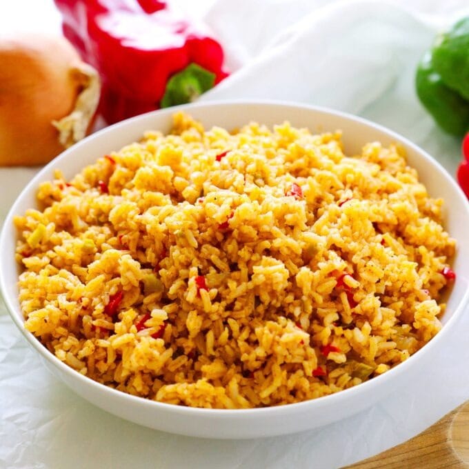 Cajun rice in a bowl spiced with paprika,. thyme, garlic, bay leaf, and pepper.