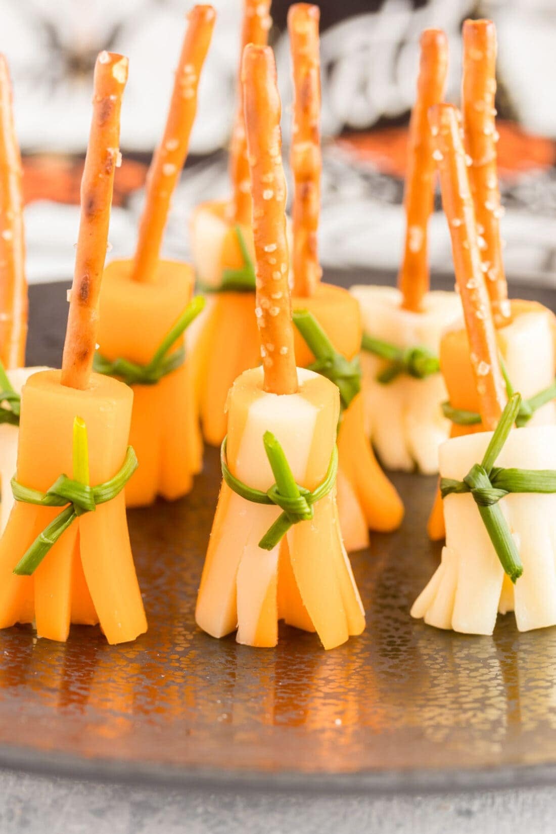 Witches broomsticks made with cheese and pretzels on an iron plate. 