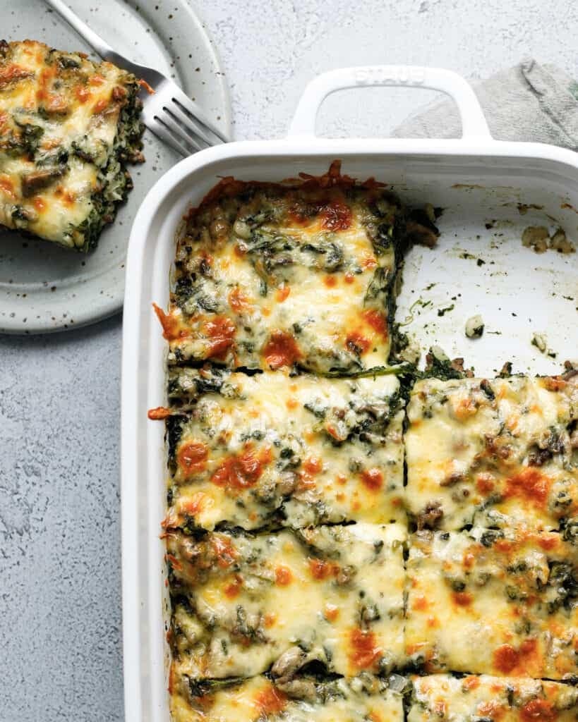 Spinach fandango casserole on a baking dish sliced in square. 