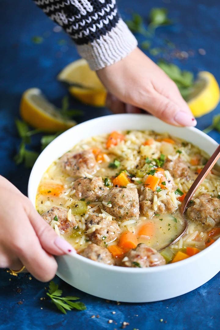 Chicken meatball noodle soup in a bowl with spoon. 