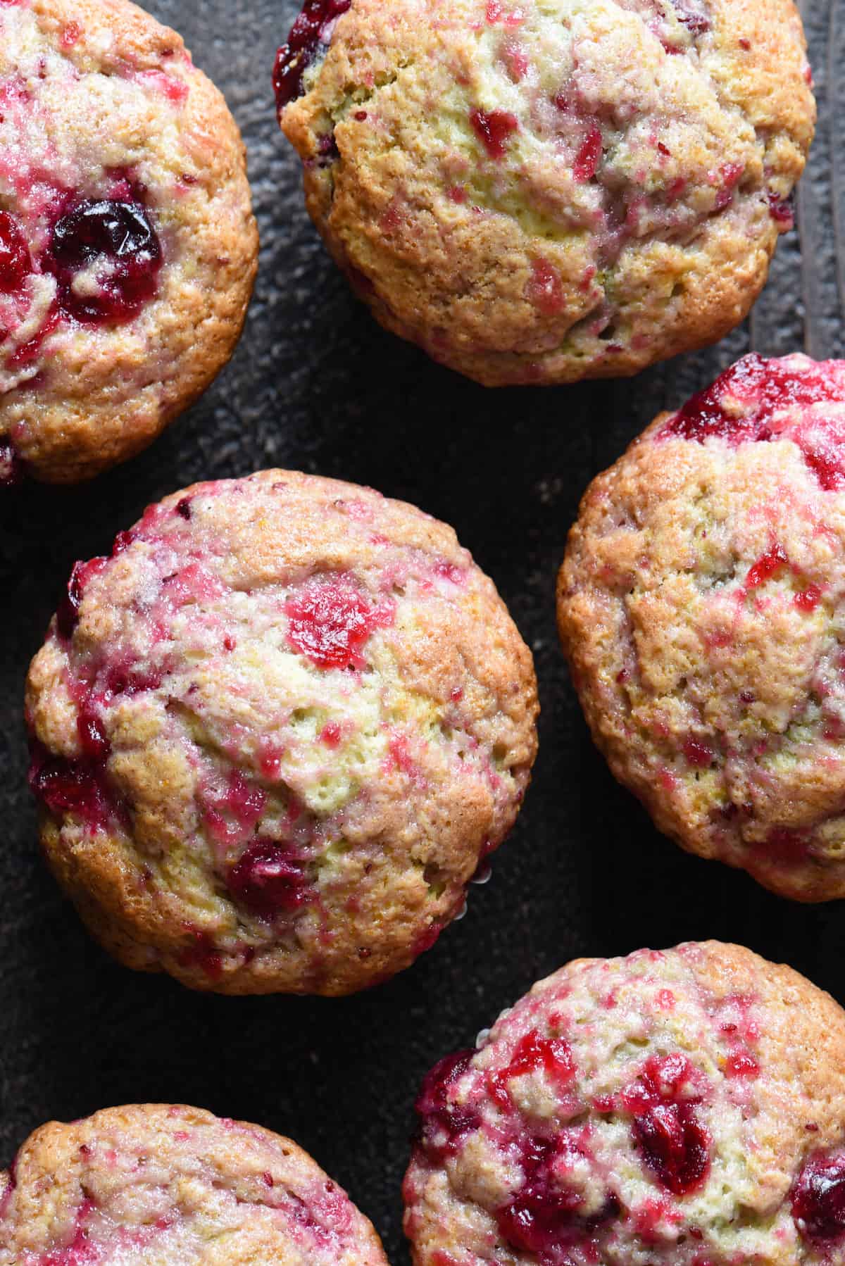 Leftover cranberry sauce muffins on a black surface.