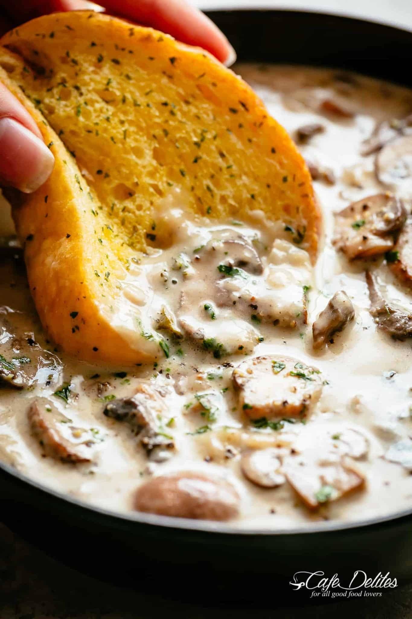 Garlic bread dipped on a Cream of Mushroom Soup