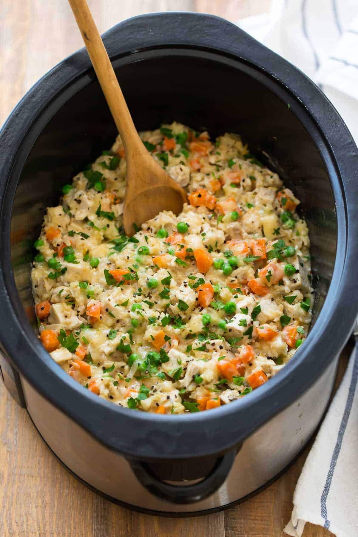 Wooden ladle dipped in a homemade Crockpot Chicken and Rice