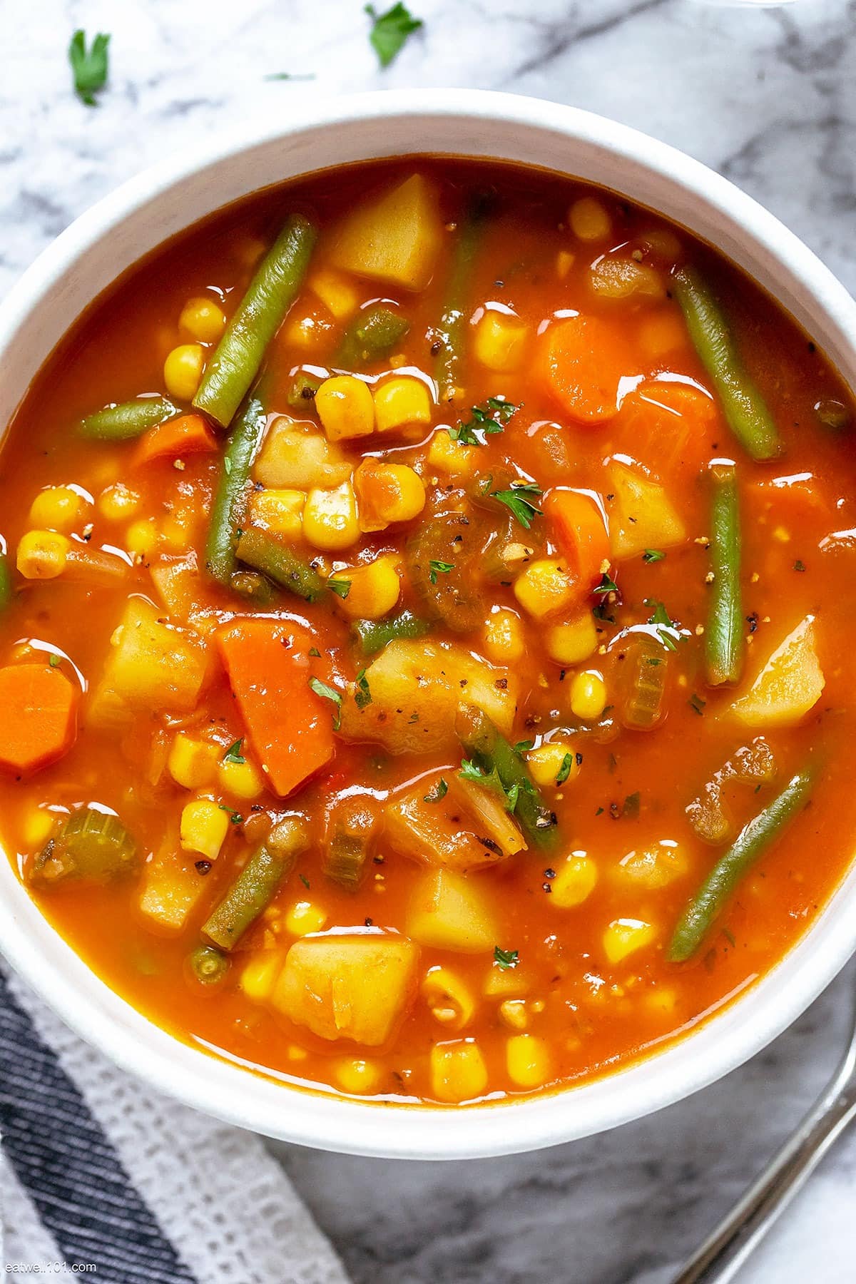 Top view of vegetable soup in a bowl with tomato sauce. 