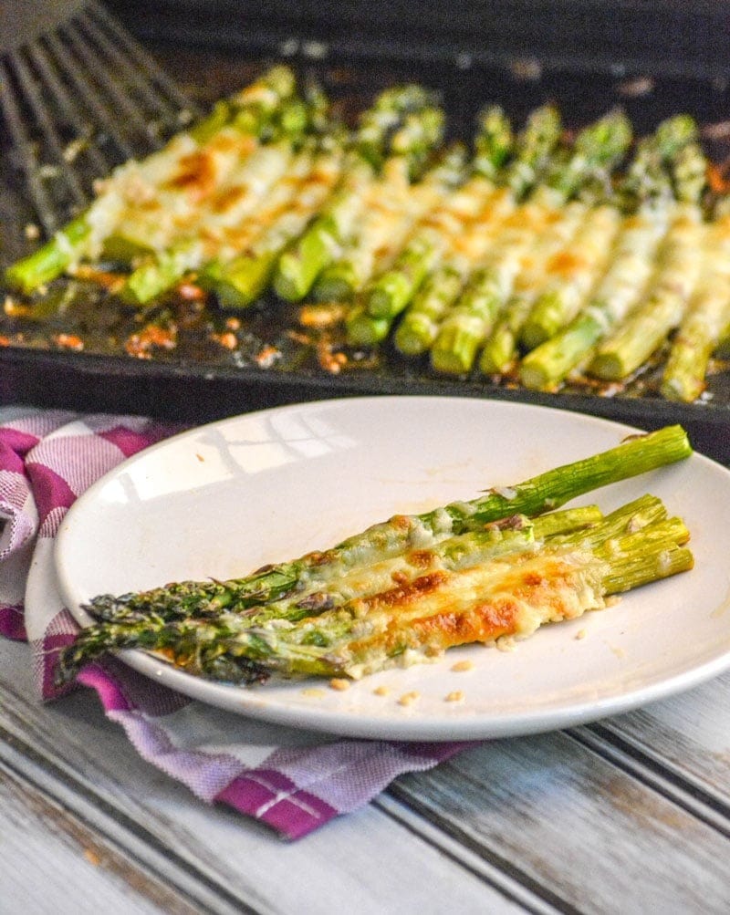 Garlic roasted cheesy sheet pan asparagus on a plate. 