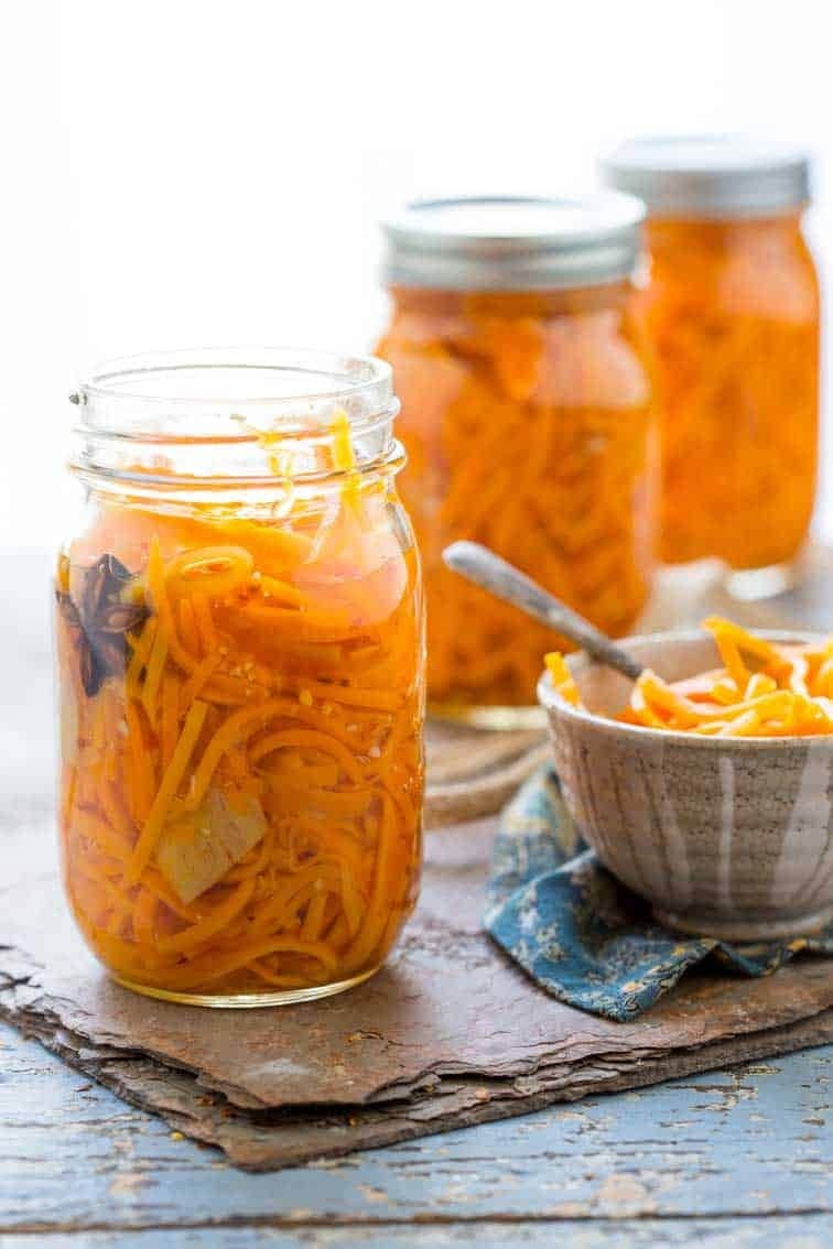 Homemade Ginger Carrot Pickles on a bowl and mason jars with unseasoned rice wine vinegar and star anise