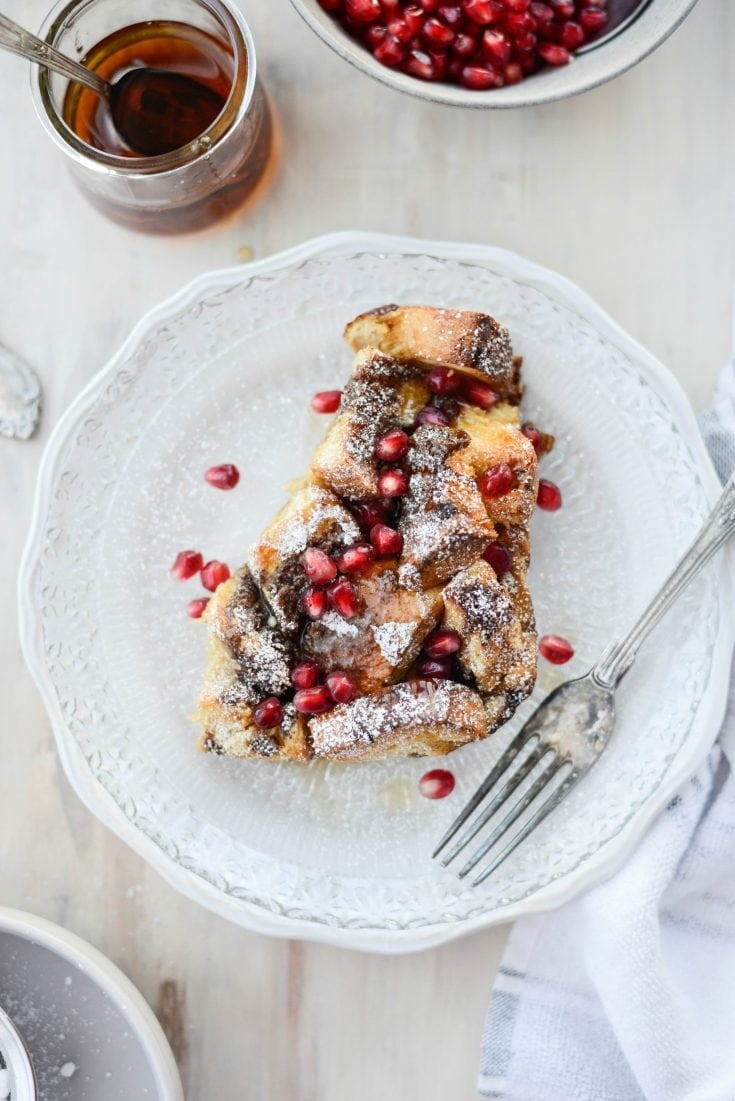 Gingerbread French toast served on a plate drizzled with maple syrup and dusted with powdered sugar. 