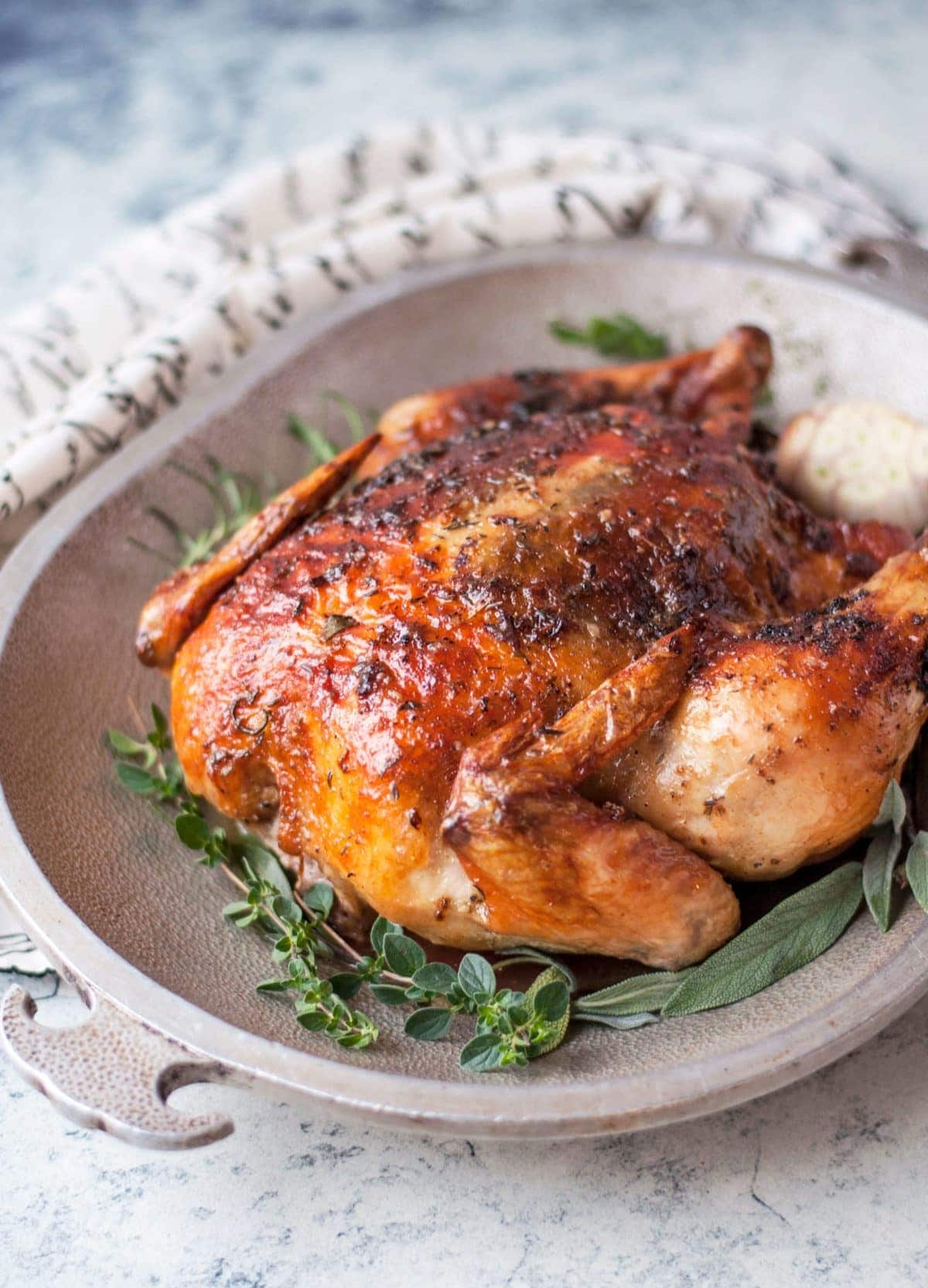 Whole herbed butter roasted chicken on a plate. 