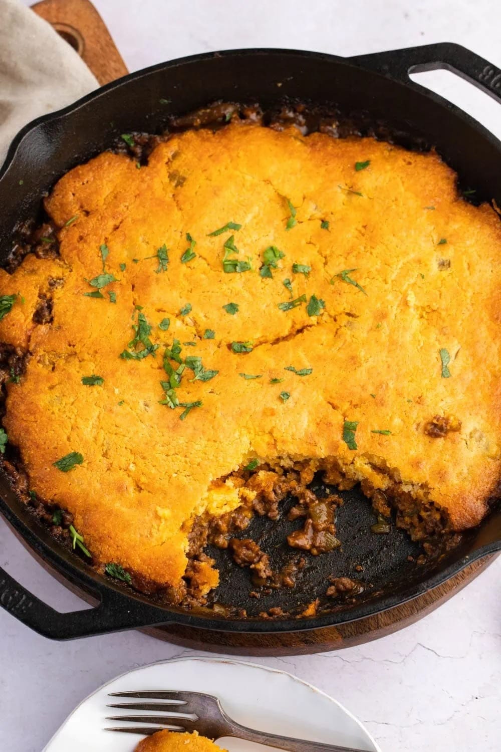 Tamale pie with cornbread, ground beef and corn on a cast iron pan.