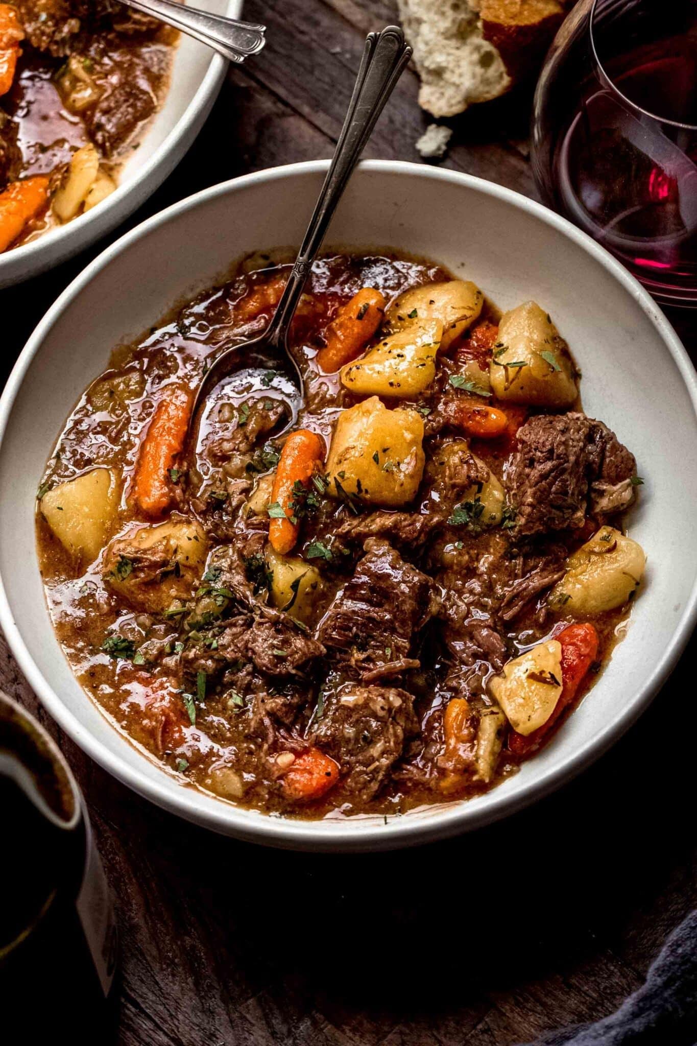 Bowl of homemade Instant Pot Beef Stew with carrots and potatoes garnished with parsley