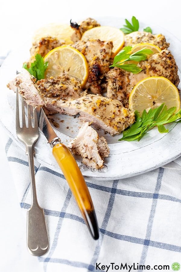 Baked Greek chicken thighs with Greek chicken marinade served on a white plate. 