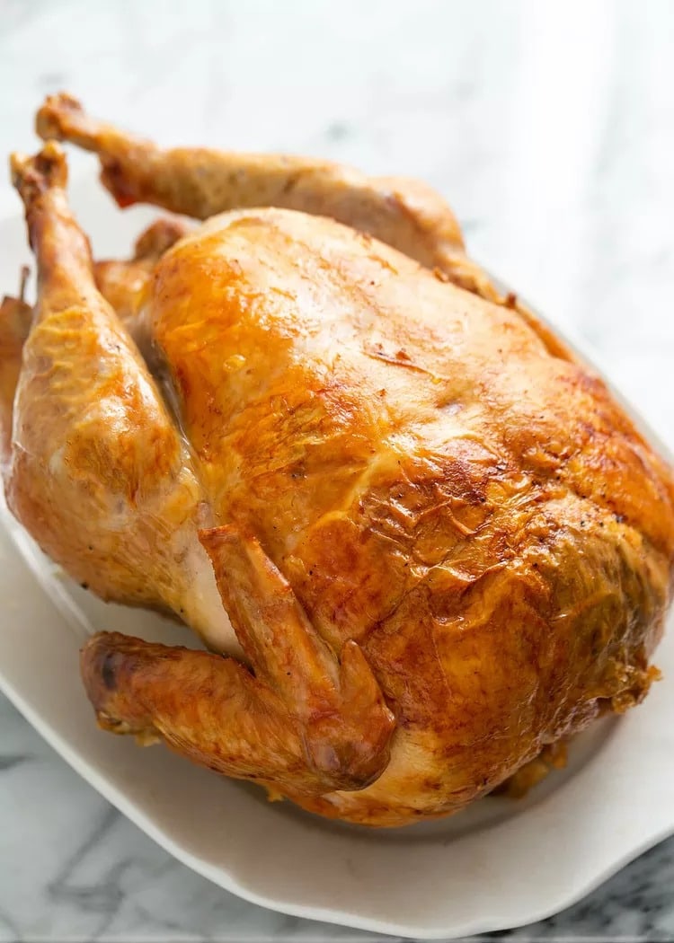 Whole Mom’s Roasted Turkey with crispy skin on an oval plate