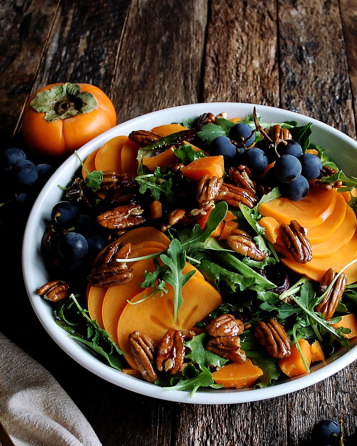 Bowl of Persimmon and Arugula Salad with Maple Mustard Vinaigrette