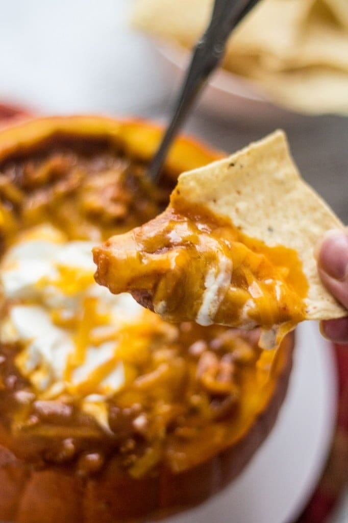 Tortilla scooping pumpkin chili on a bowl. 