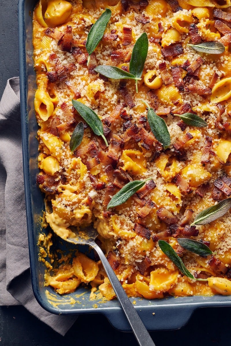 Pumpkin mac and cheese served on a black casserole. 