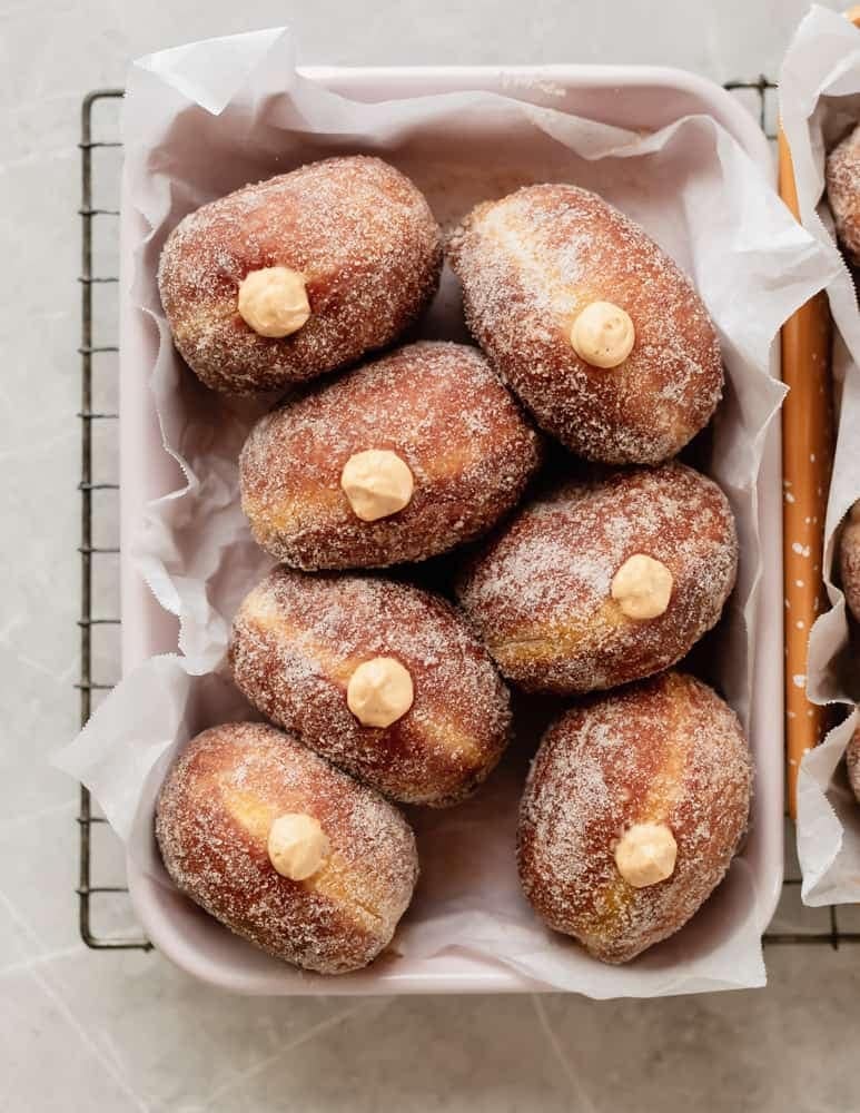 Pumpkin brioche cheesecake doughnuts on a bread basket. 