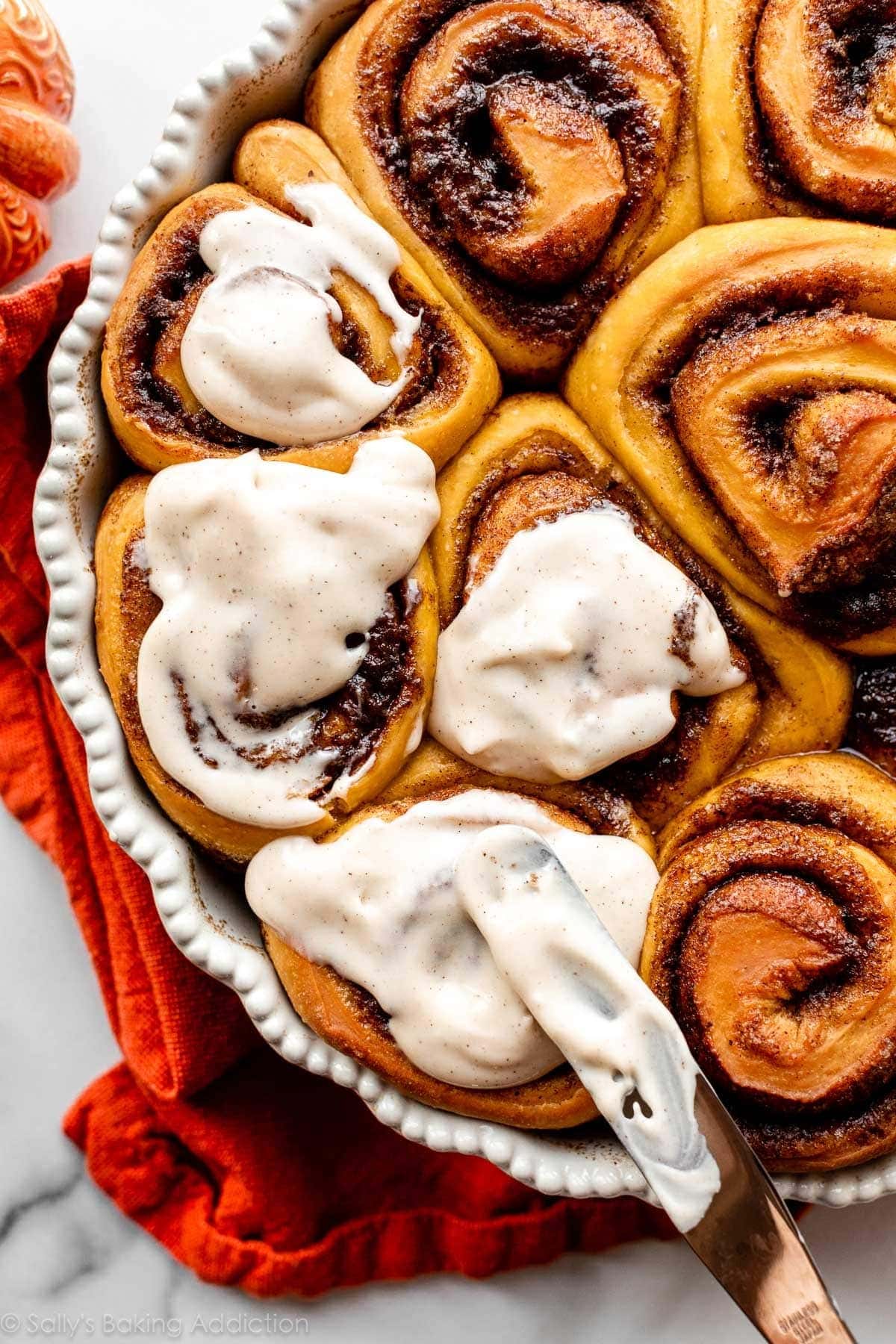 Pumpkin cinnamon rolls with cream spread on top. 