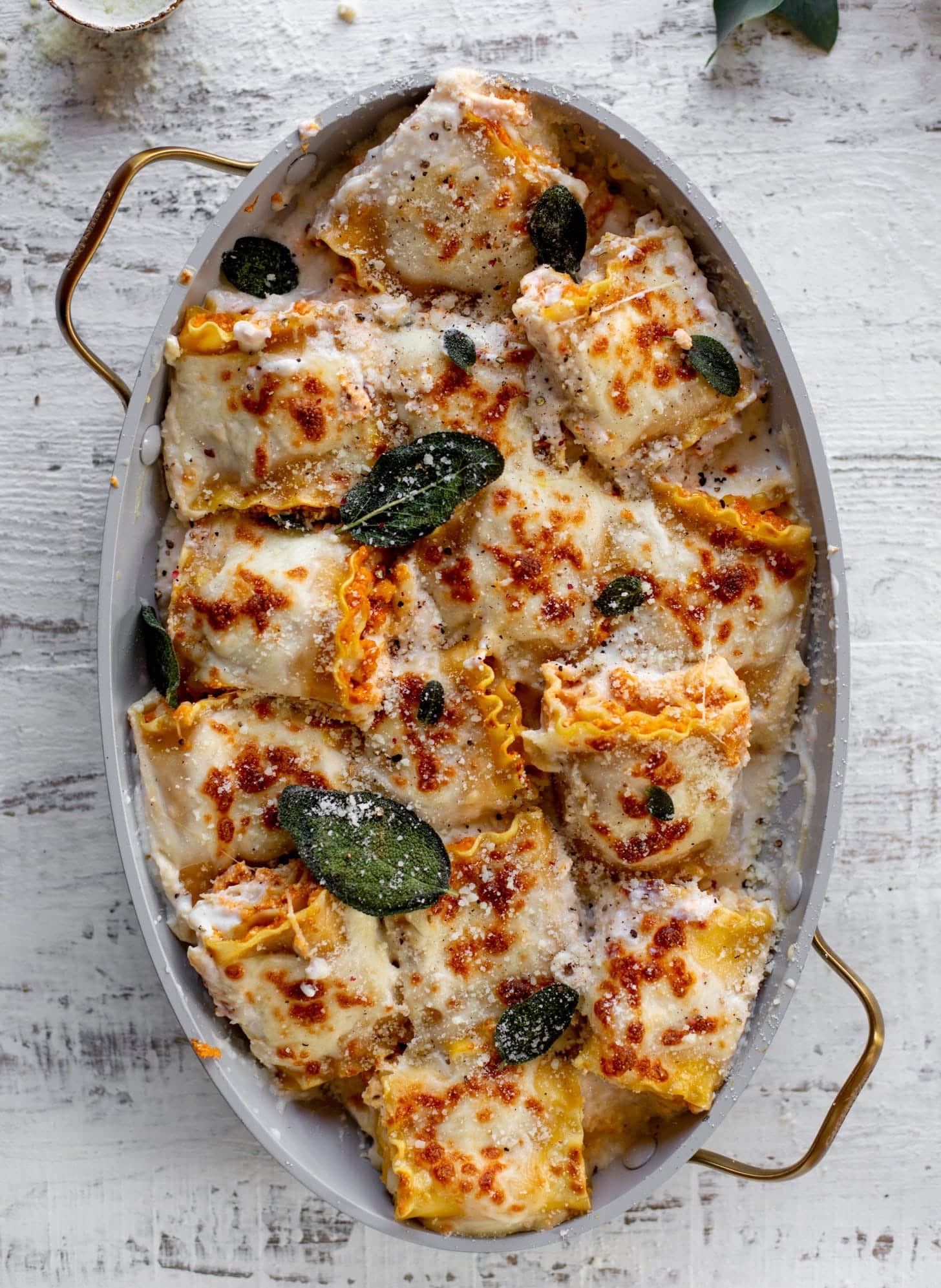 Pumpkin lasagna roll ups with crispy sage in a boat shaped-pan. 