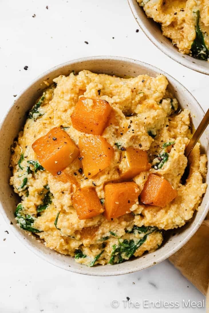 Bowl with pumpkin poleta mixed with goat cheese and spinach.