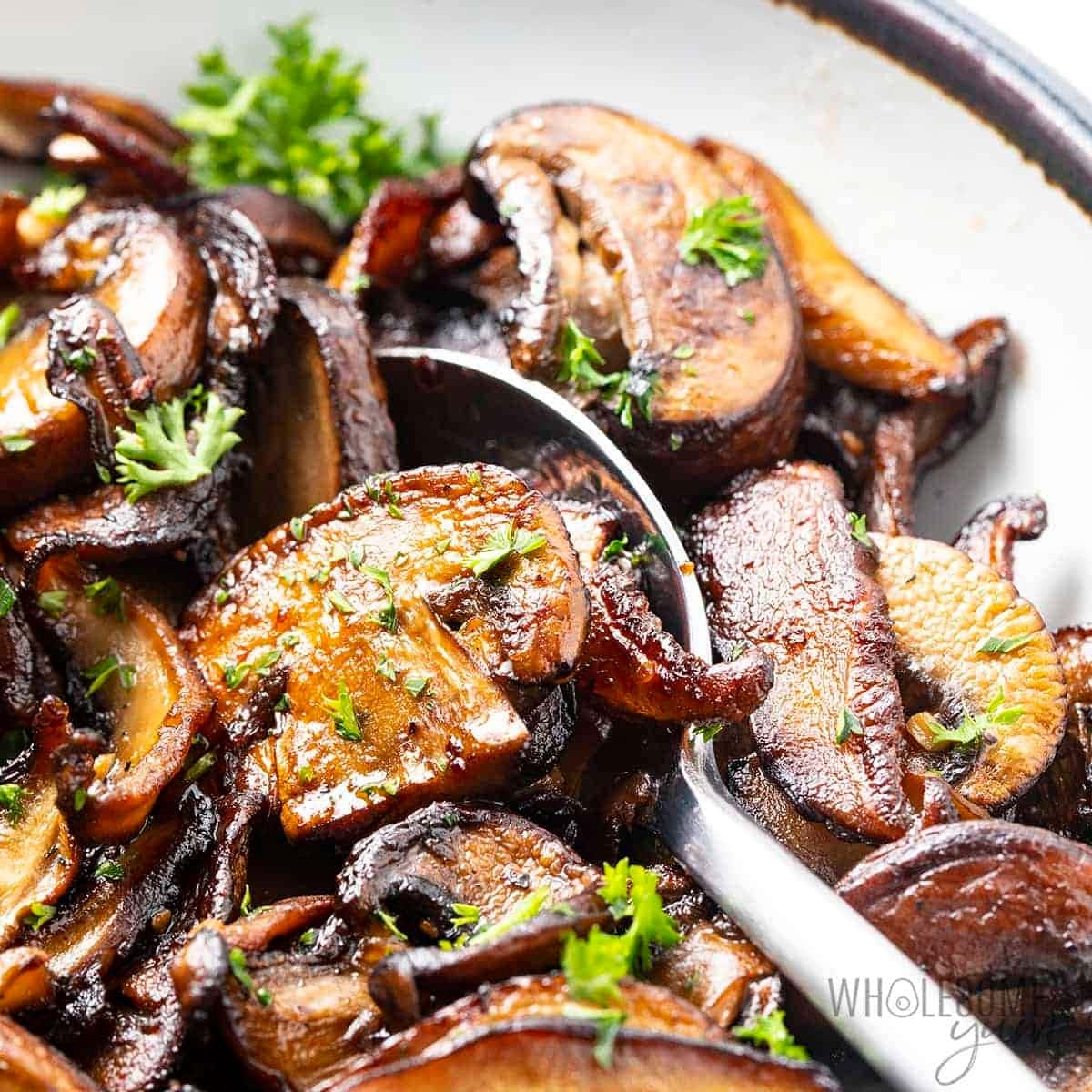 Sauteed mushroom in a bowl with spoon. 