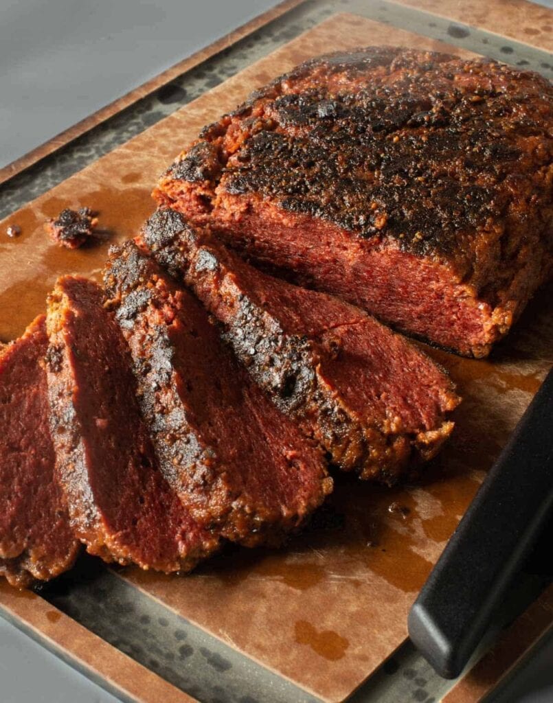 Sliced roast beef in a wooden cutting board.