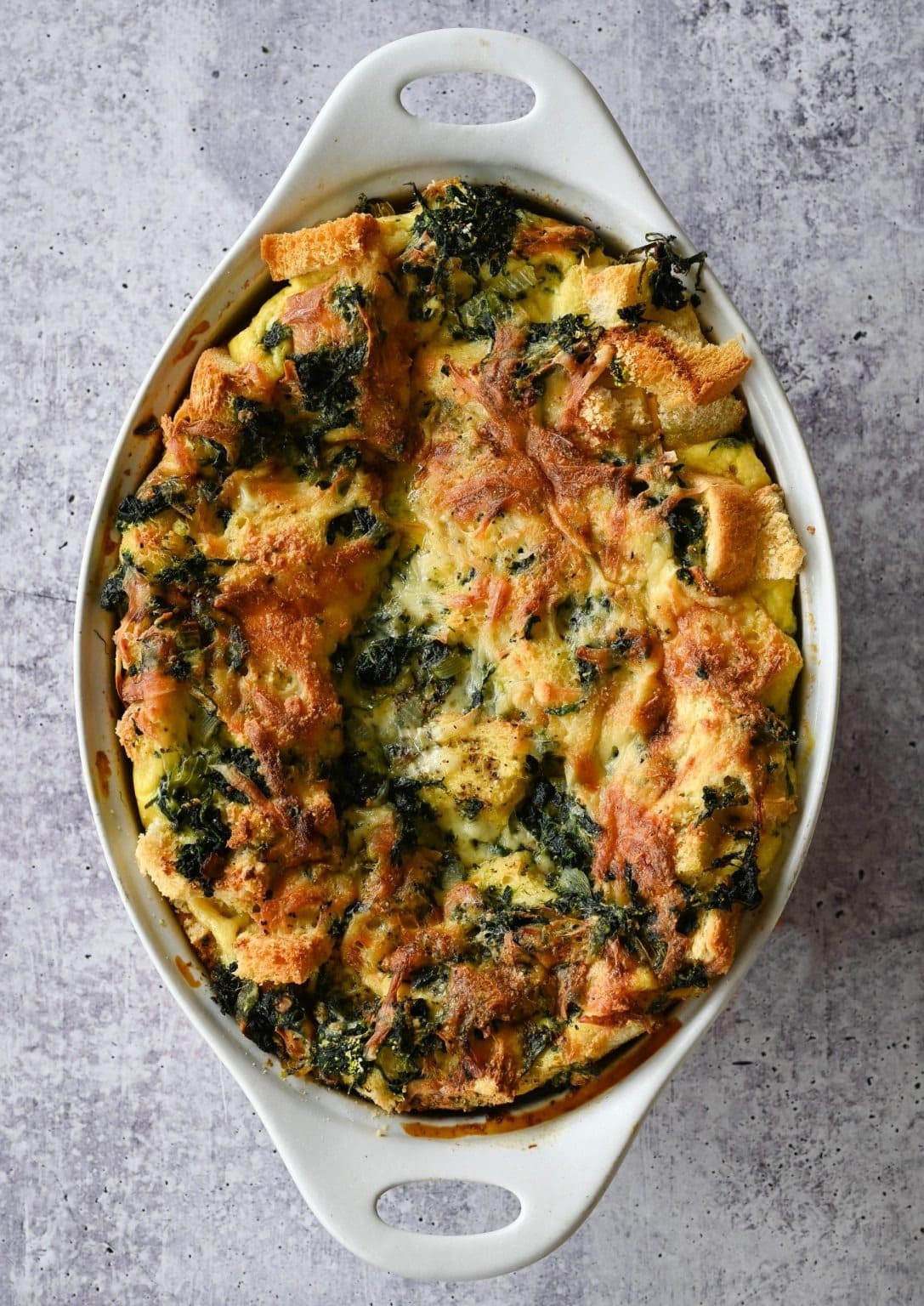 Egg casserole layered with spinach, cheese, and bread, and soaked in a savory custard