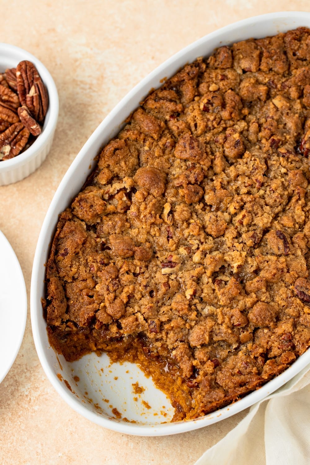 Sweet potato casserole in a white dish with crumbly toppings.