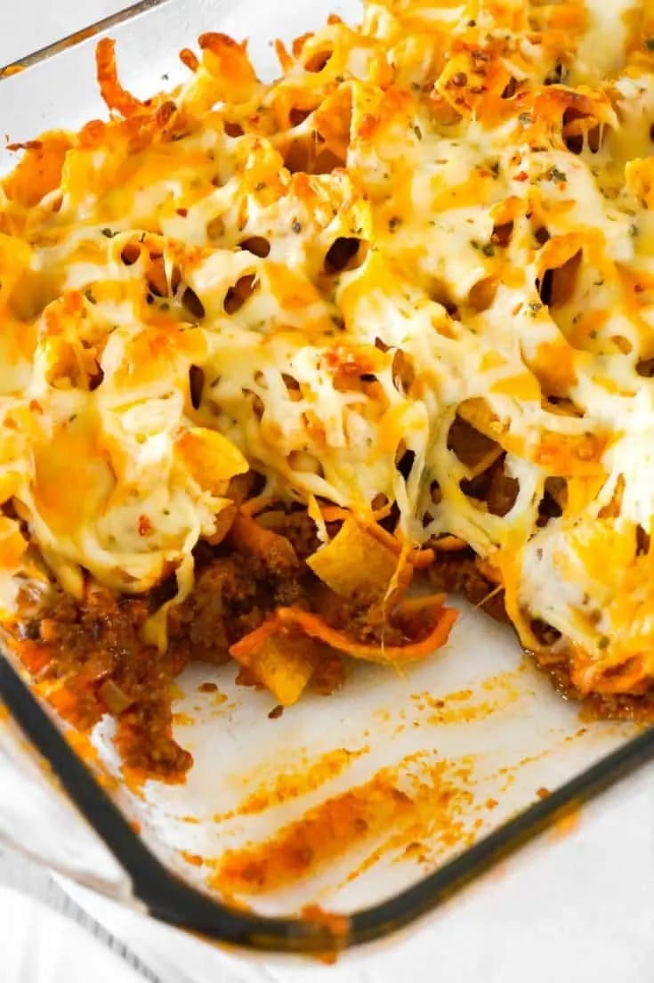 Sloppy joe Frito pie prepared on a glass baking dish. 