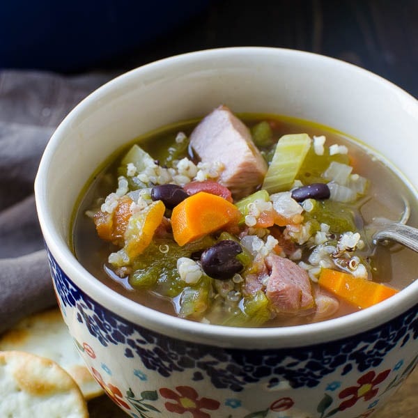 Spicy hatch chile and ham soup loaded with veggies, hatch chiles, beans, and ham served in a bowl 