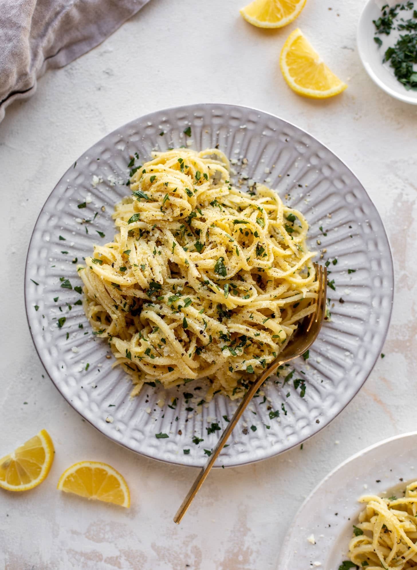 Pasta with artichoke sauce garnished with chopped parsley and herbs.