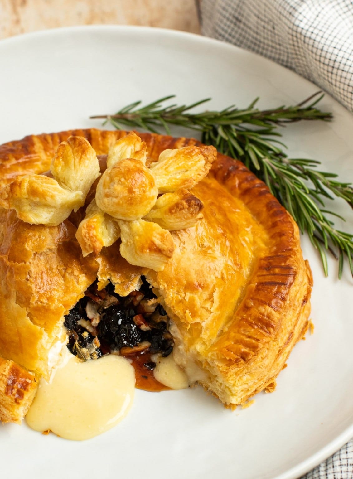 Baked brie en croûte with honey, dried cherries, rosemary & pecans.