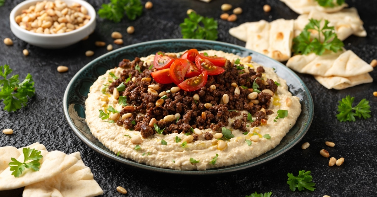 Homemade Hummus with Ground Beef in a Bowl Topped with Tomatoes