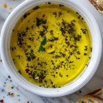 Close Top View of Carrabba's Bread Dip with Olive Oil, Rosemary, Herbs, Pepper, and Other Spices with Crusty Bread