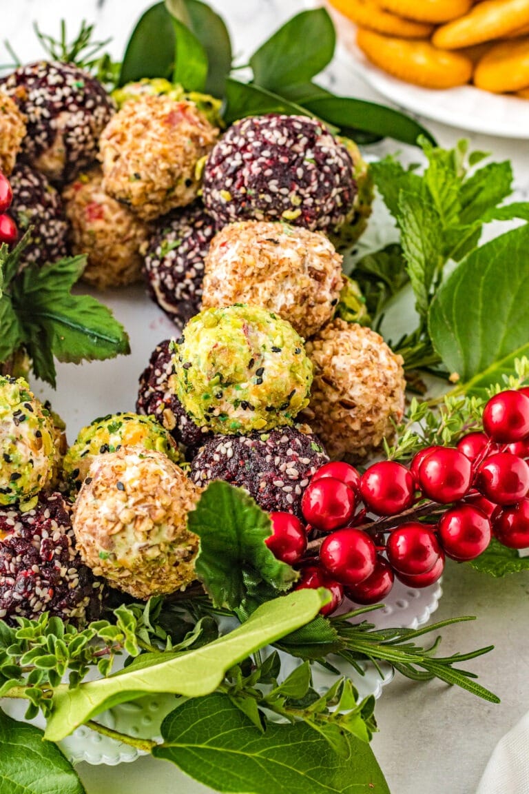 Mini cheese ball rolled in pecans, cranberries, or dried wasabi peas shaped in Christmas wreath.  