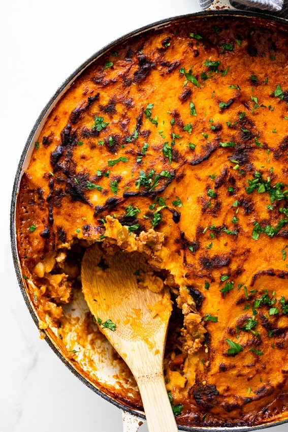 Portion missing of chicken cottage pie on a pan.