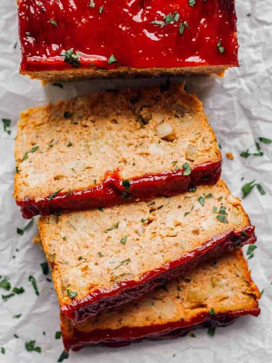 Sliced chicken meatloaf with sauce on top. 