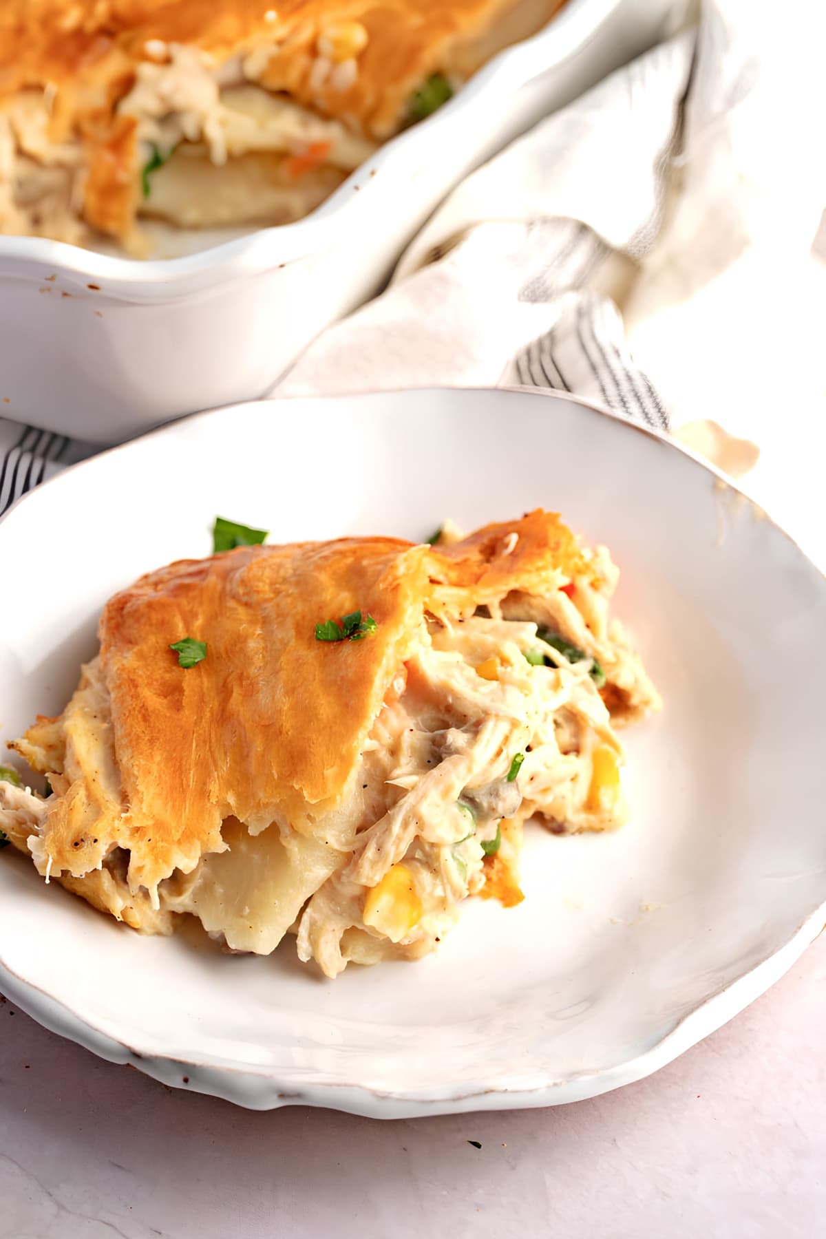 A piece of chicken pot pie with crescent rolls, vegetables, cream of chicken and mushroom soup