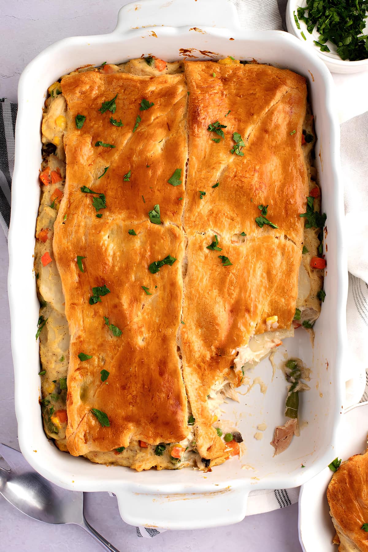 Chicken pot pie made with crescent rolls in a white casserole dish