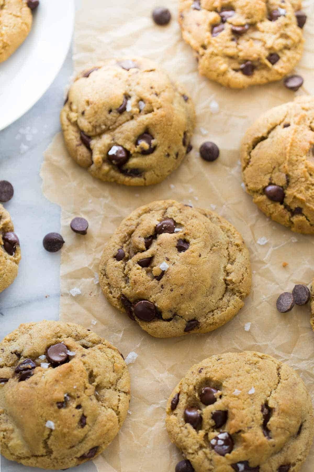 Chocolate chip cookies sprinkles with rock salt on a parchment paper. 