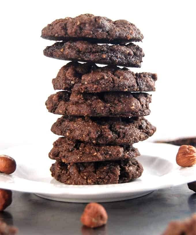 Chocolate hazelnut cookies stacked on a white plate.