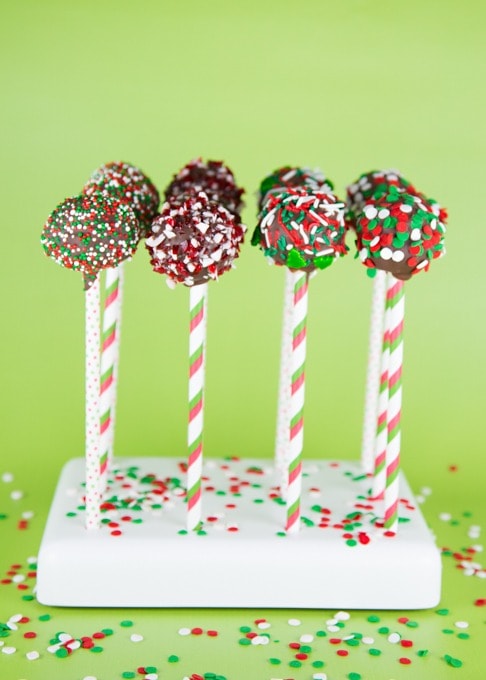 Chocolate cake pops on stick covered with colorful sprinkles. 
