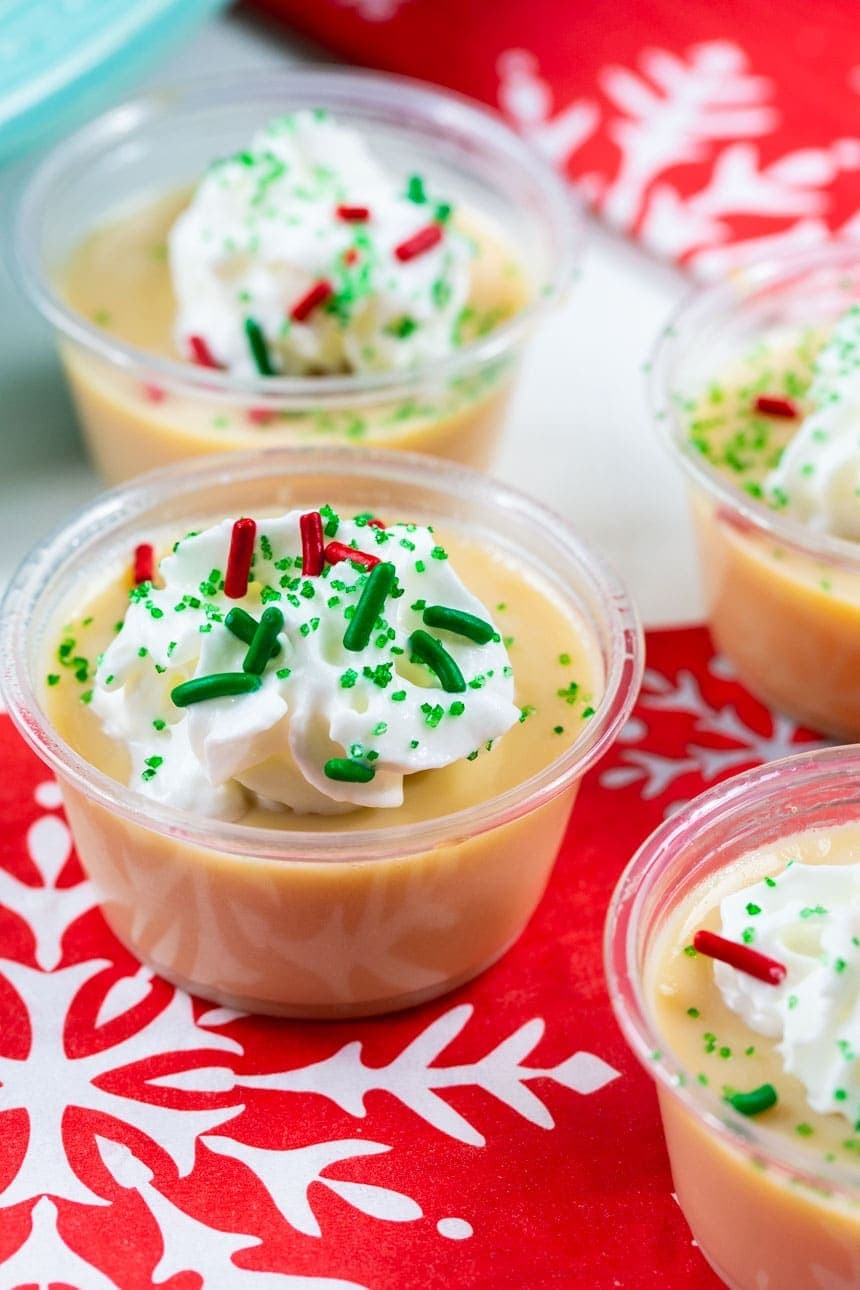 Butterscotch flavor Jello shots on plastic cups with whipped cream and sprinkles on top. 